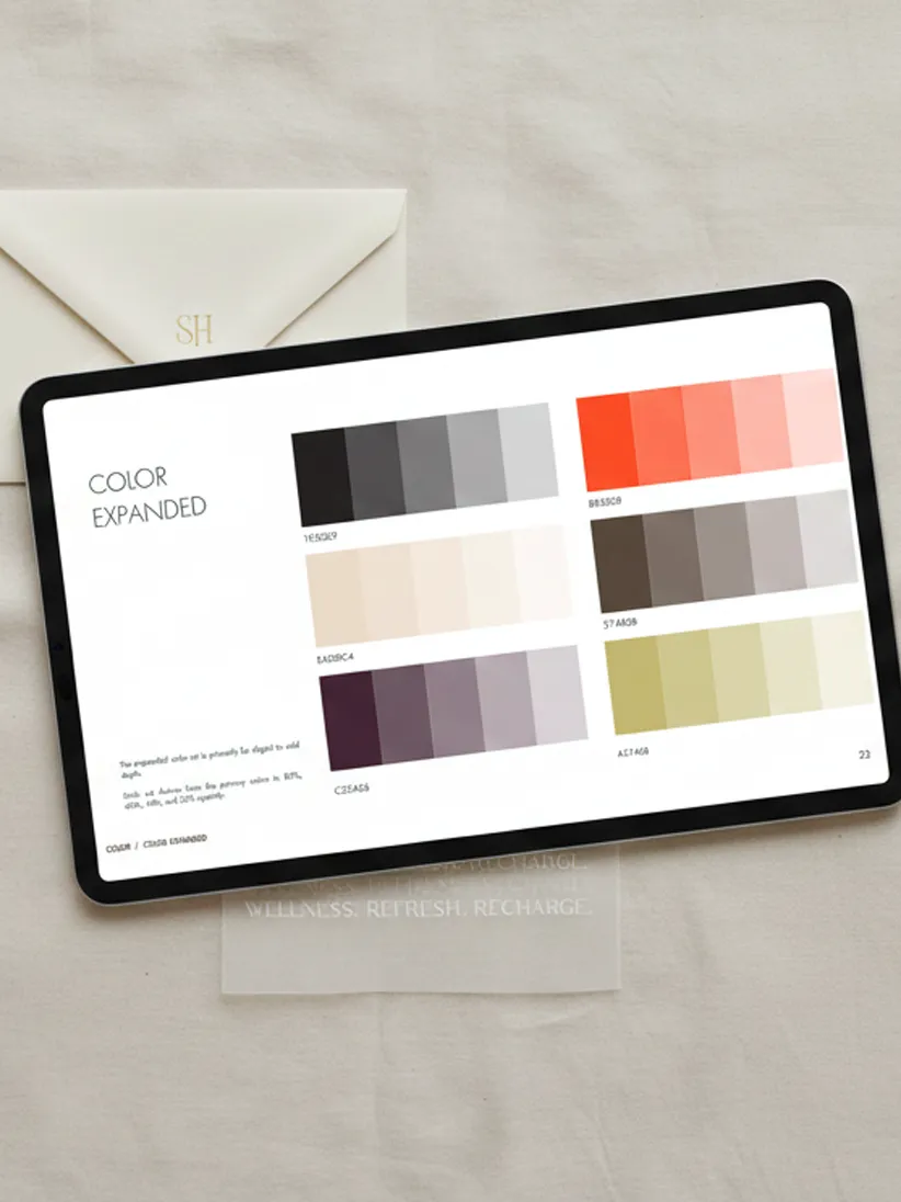 A flat lay of an iPad showing a "Color Expanded" brand guide page, accompanied by a cream envelope and earthy-toned color swatches on a linen background, showcasing Alter Edit Brand Book Templates.